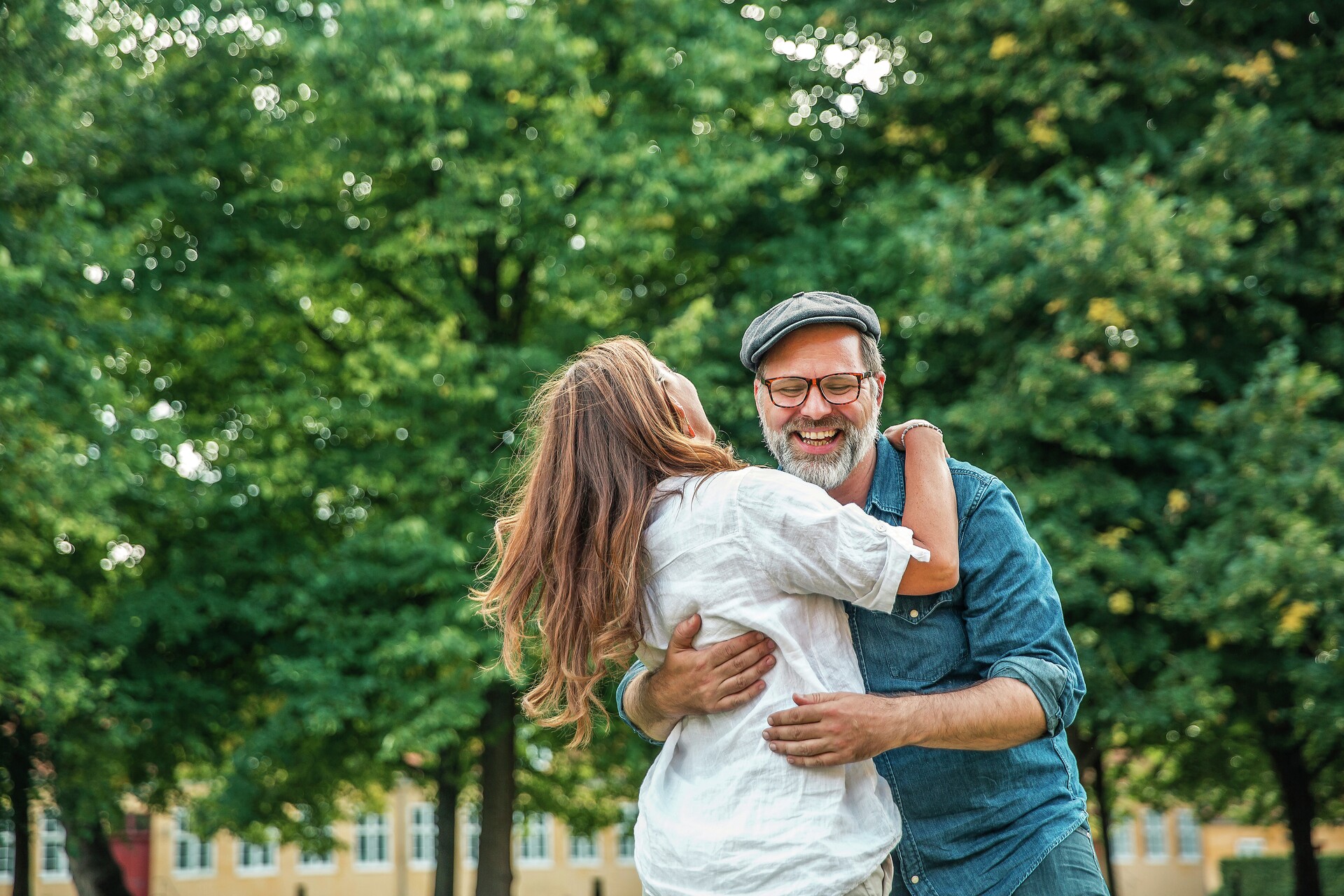 Par krammer og danser i park, fotografi